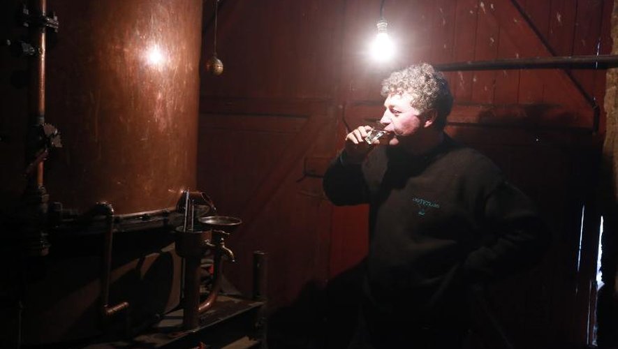 Marc Saint-Martin, bouilleur de cru itinérant d'Armagnac, goute un verre dans sa distillerie itinérante installée dans le château de Ravignan, à Perquie (Landes), le 17 novembre 2014