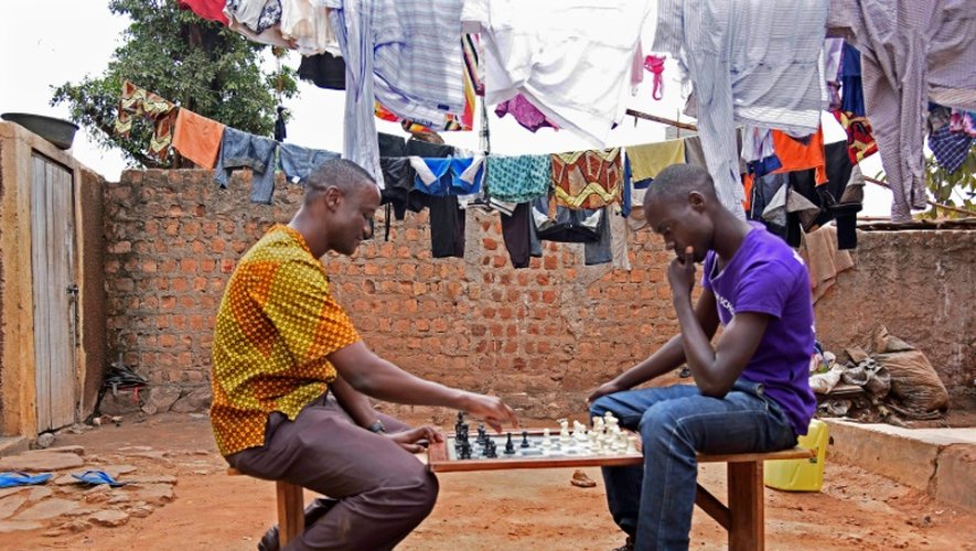 Robert Katende (g) et  Brian Mugabi (d), respectivement coach et frère de Phiona Mutesi, jouent aux échecs, au club  d'échecs de Katwe, banlieue de Kampala, le 29 septembre 2016
