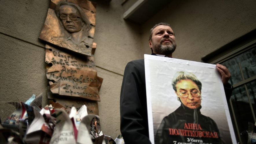 Un homme tient un portrait de la journaliste russe Anna Politkovskaïa assassinée le 7 octobre 2006 lors d'une manifestation à Moscou, le 7 octobre 2014