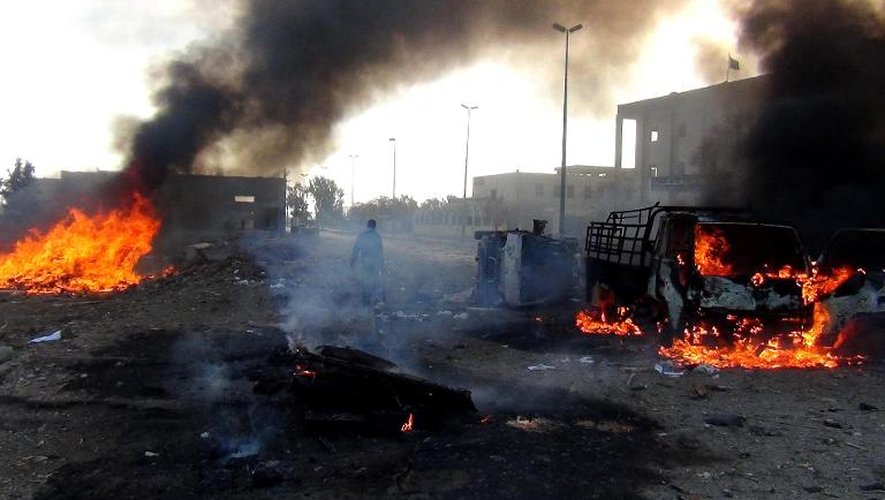 Véhicules en feu après des frappes menées par le régime syrien le 25 novembre 2014 à Raqa