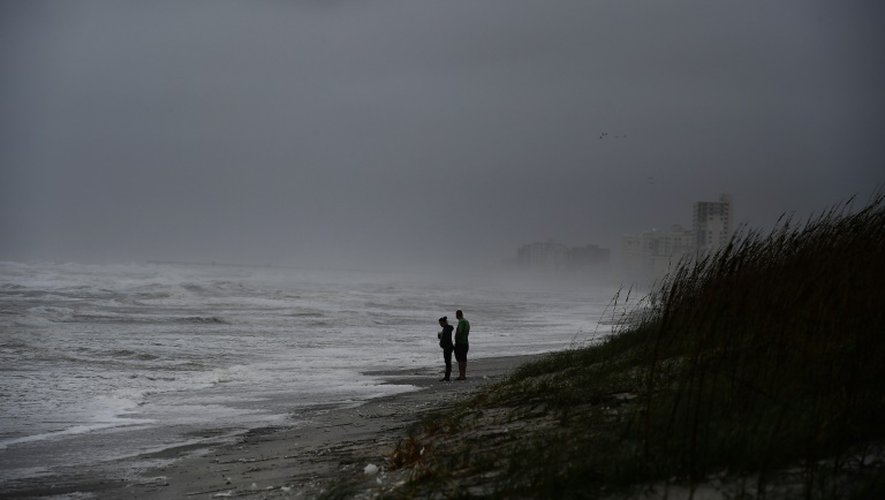 Des américains sur la plage de Jacksonville balayée par des vents et des pluies avant l'arrivée de l'ouragan Matthew, le 6 octobre 2016 en Floride
