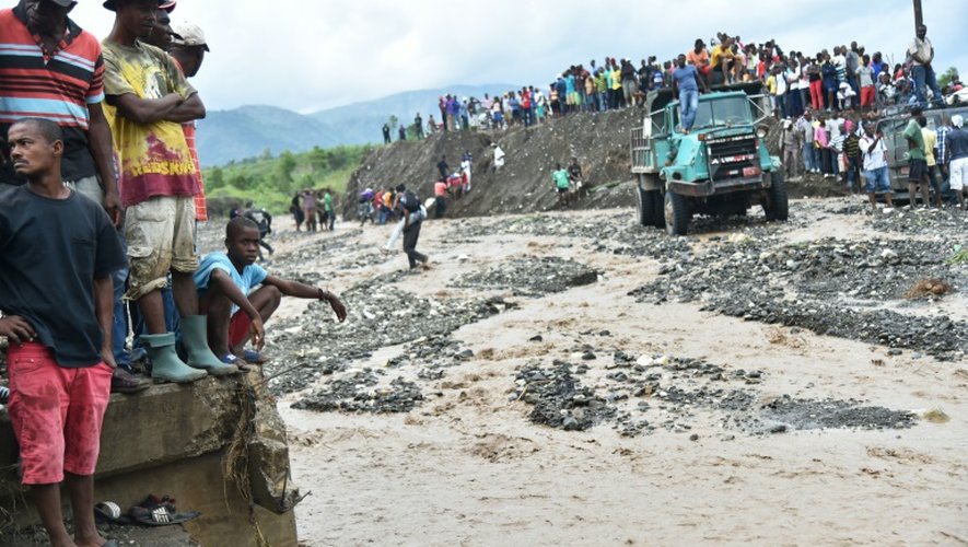 Des personnes tentent de traverser la rivière La Digue à Petit Goave dans le su-ouest de Port-au-Prince, le 6 octobre 2016