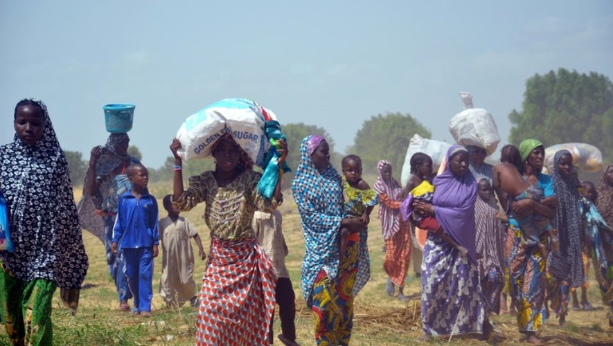 Des femmes et des enfants fuient leurs maisons incendiées par des islamistes de Boko Haram, le 3 juillet 2015 à Zabarmari, près de Maiduguri, au nord-est du Nigeria