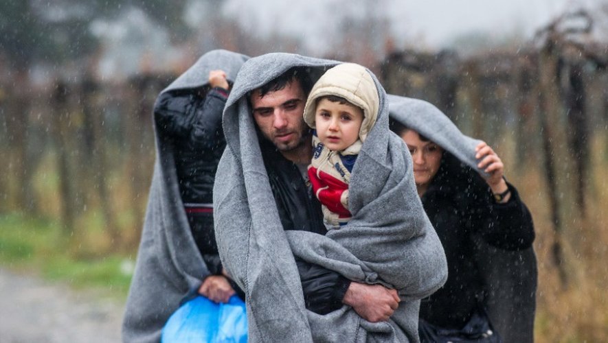 Des migrants marchent sous la pluie après avoir traversé la frontière entre la Grèce et la Macédoine, à Gevgelija, le 27 novembre 2015