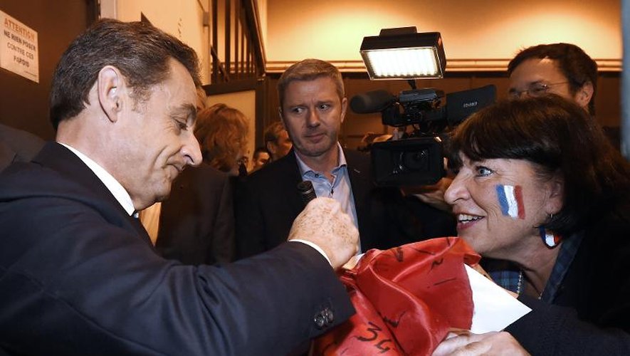 L'ancien président Nicolas Sarkozy signe des autographes à son arrivée à Nîmes, le 27 novembre 2014 pour un meeting électoral
