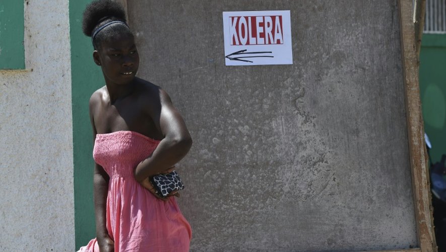 Une femme devant une affiche sur laquelle on peut lire "choléra" dans un hôpital de Port-Salut, au sud-ouest de Port-au-Prince, le 9 octobre 2016