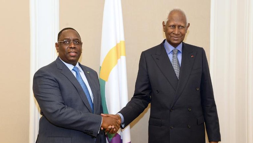 Le secrétaire général de la Francophonie, Abdou Diouf (d), serre la main du président sénégalais Macky Sall, le 21 novembre 2014 à Paris