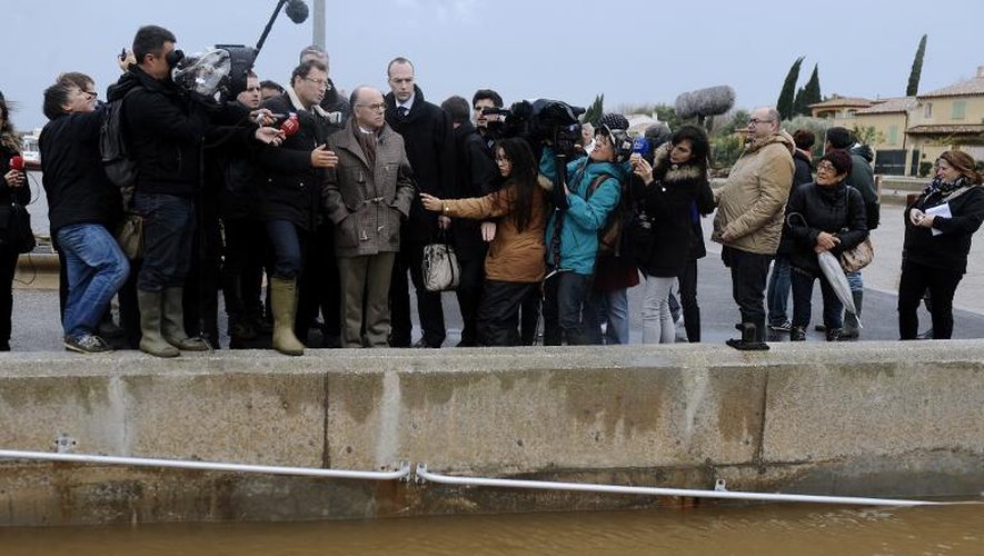 Le ministre de l'Intérieur Bernard Cazeneuve devant les quais de la Maravenne à Londes après les fortes pluies, le 29 novembre 2014