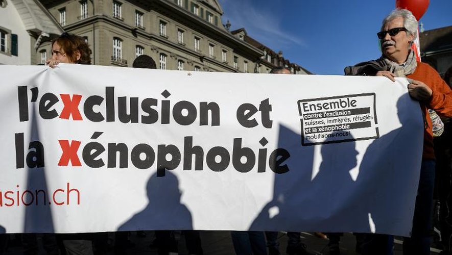 Un homme brandit une pancarte contre l'exclusion et la xénophobie, lors d'une manifestation à Berne le 27 novembre 2014