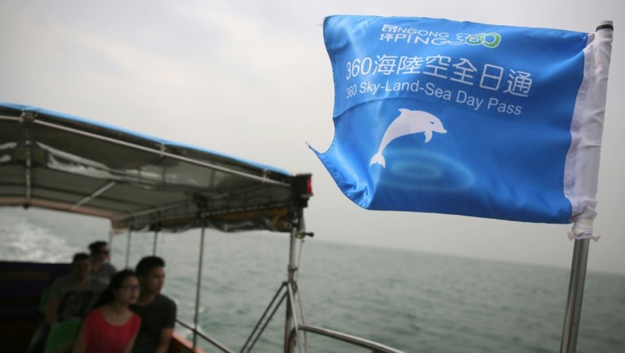 Des touristes font un tour en bateau pour essayer d'apercevoir les dauphins roses à Tai O, à Hong Kong, le 4 novembre 2015