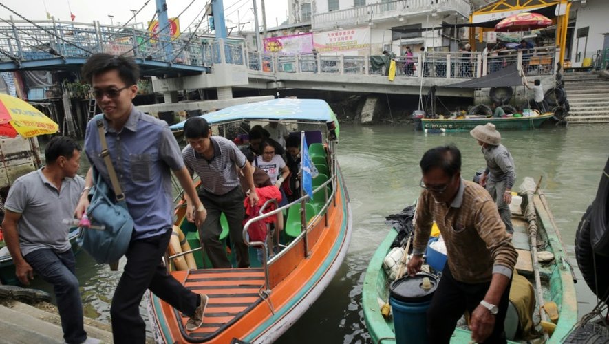 Des touristes reviennent d'un tour en bateau pour voir les dauphins roses, à Tai O, à Hong Kong, le 4 novembre 2015