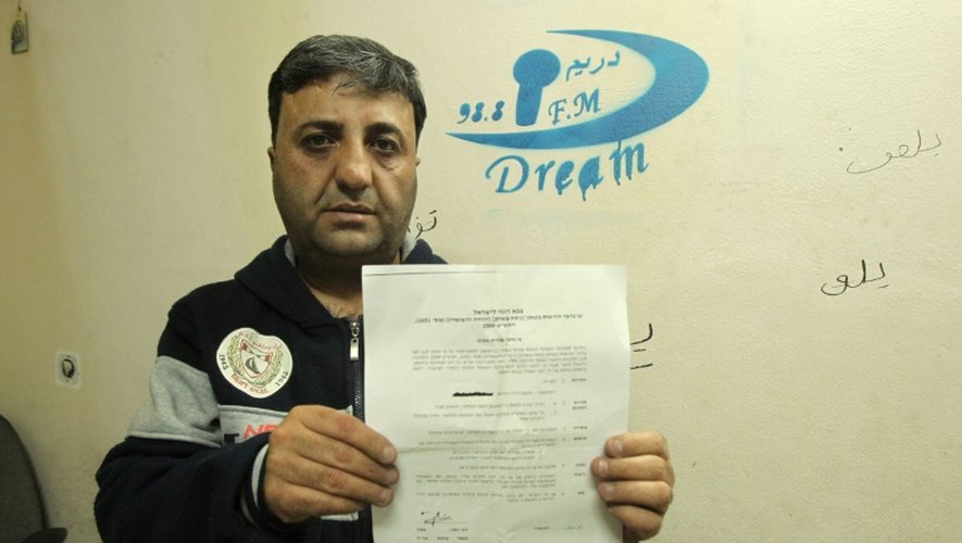 Le propriétaire de la station de radio "Dream", Talab Jaabari, montre l'ordre de fermeture pour six mois de cette troisième radio d'Hébron, le 29 novembre 2015
