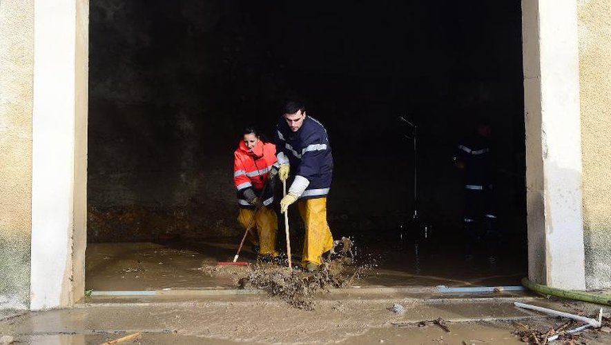 Des pompiers volontaires aident à nettoyer une maison après la crue de la Berre, à Portel-des-Corbières dans l'Aude, le 1er décembre 2014