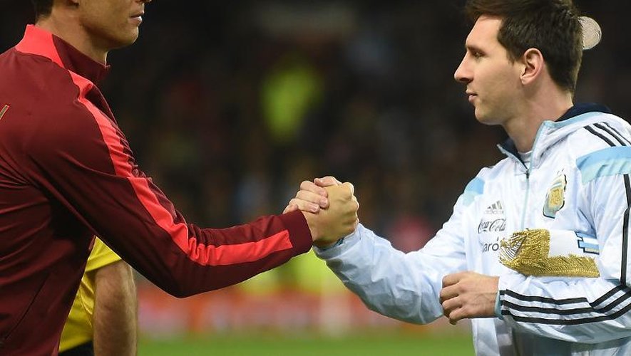 L'Argentin Lionel Messi (d) serre la main du Portugais Cristiano Ronaldo (g) avant un match amical Argentine-Portugal à Manchester le 18 novembre 2014