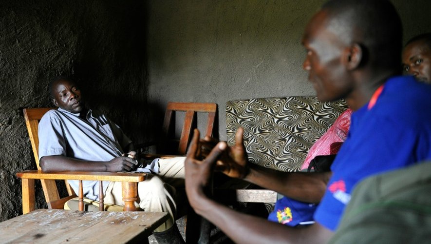 Un agent médical Ken Olela (d) s'entretient avec Lawrence Owino pour le convaincre lui et sa famille de passer des tests de depistage du sida, à Ndiwa dans le comté de Homa Bay (ouest du Kenya), le 10 novembre 2015