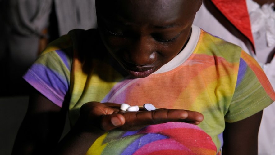 Une jeune kenyane de 13 ans Claudia Aulo prend ses médicaments pour traiter le sida le 9 novembre 2015 dans le comté de Homa Bay (ouest du Kenya)