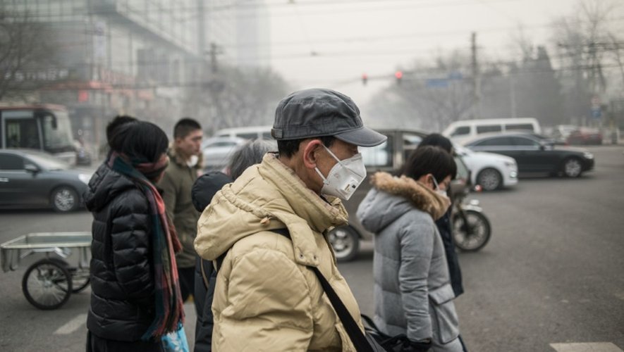 Des piétons portent des masques antipollution dans les rues de Pékin le 30 novembre 2015