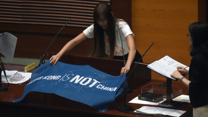 La nouvelle députée Yau Wai-ching déplie un drapeau sur lequel on peut lire "Hong Kong n'est pas la Chine" lors de sa prestation de serment au "Parlement", le 12 octobre 2016 à Hong Kong