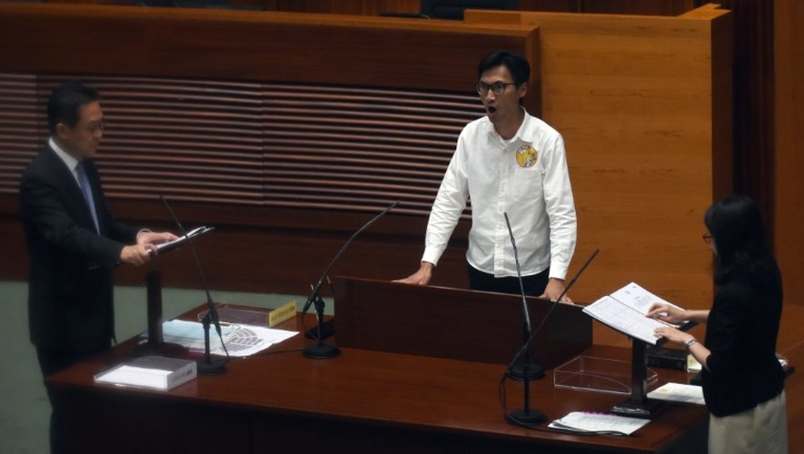 Le nouveau député Eddie Chu (c) crie des slogans en faveur de l'autodétermination démocratique lors de sa prestation de serment au "Parlement" de Hong Kong, le 12 octobre 2016
