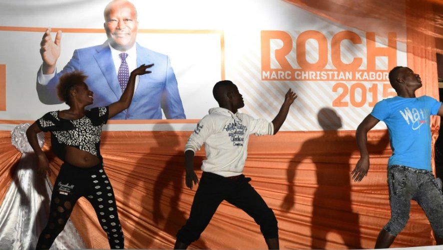 Des artistes dansent devant une affiche de Roch Marc Christian Kaboré à Ouagadougou le 1er décembre 2015