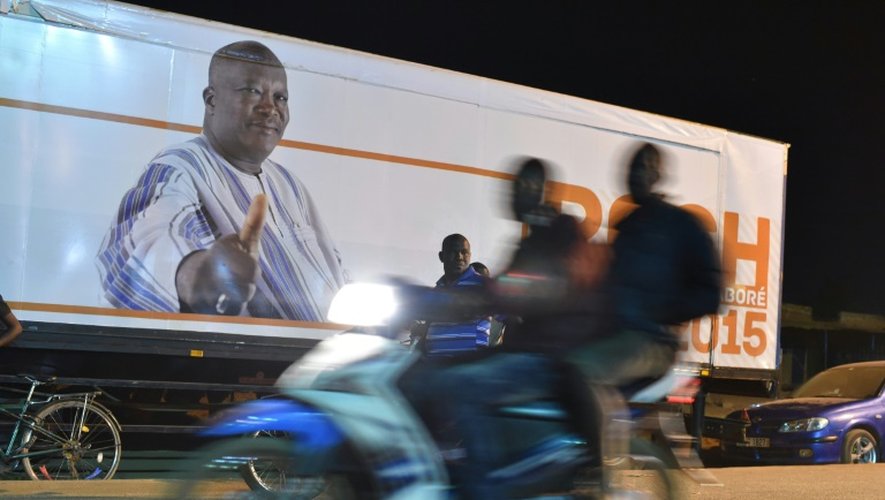 Des militants burkinabè fêtent la victoire à la présidentielle de Roch Marc Christian Kaboré (arrière-plan) à Ouagadougou le 1er décembre 2015