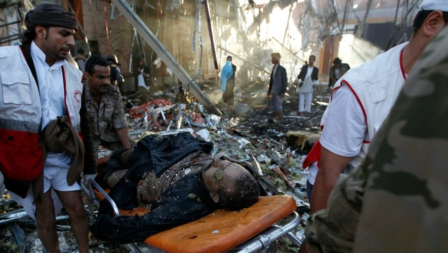 Des sauveteurs transportent un blessé dans le bombardement meurtrier d'une cérémonie funéraire, le 8 octobre 2016 à Sanaa, au Yémen