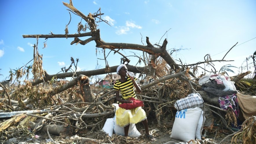 Une Haïtienne, victime de l'ouragan Matthew, vient de recevoir des rations alimentaires de l'aide humanitaire, à Roche-a-Bateaux, le 12 octobre 2016 dans les Cayes
