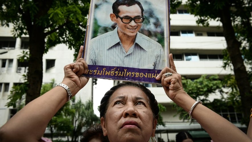 Une Thaïlandaise brandit le portrait du roi de Thaïlande Bhumibol Adulyadej et prie pour son rétablissement devant l'hôpital de Bangkok, où le souverain est soigné, le 12 octobre 2016