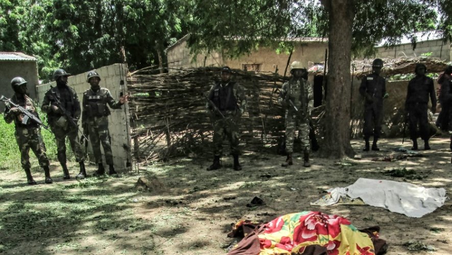 Des membres de la sécurité camerounaise devant la dépouille d'une victime d'un attentat suicide à Kolofata, dans l'extrême nord du Cameroun, le 13 septembre 2015