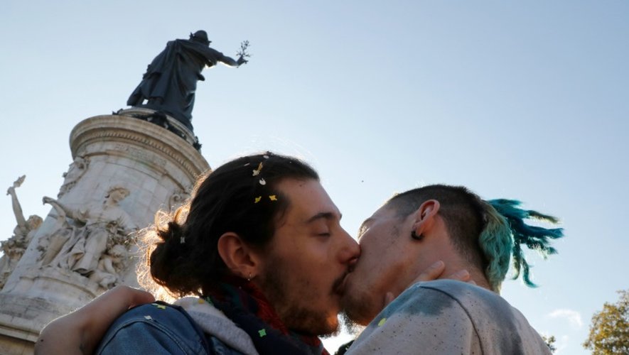 Un homme en embrasse un autre lors de la contre-manifestation à celle "pour tous" demandant l'abrogation du mariage homosexuel, place la République le 16 octobre 2016