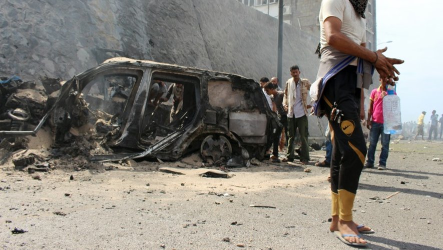 Des yéménites sur les lieux de l'attentat à la voiture piégée qui a tué le gouverneur de la province d'Aden et à au moins six gardes du corps, le 6 décembre 2015 à Aden