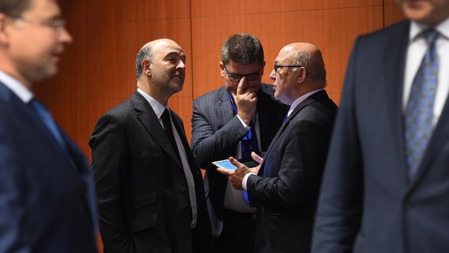 Le ministre des Finances français Michel Sapin (2e à d) et le commissaire européen chargé de la Fiscalité, Pierre Moscovici (2e à g) à Bruxelles, le 8 décembre 2014