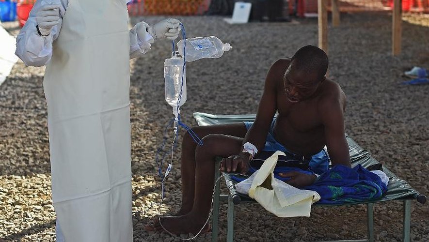 Une infirmière assiste un patient atteint du virus Ebola, au centre de traitement de Kenama, en Sierra Leone, le 15 novembre 2014