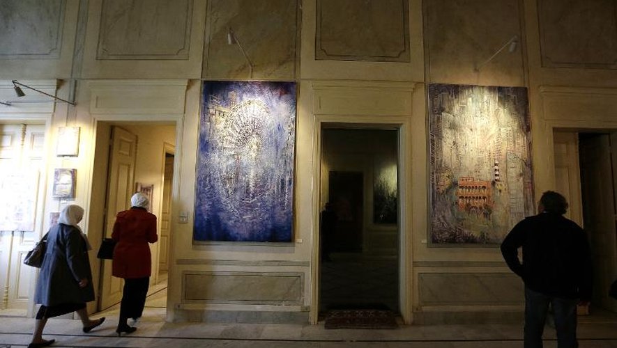 Des visiteurs admirent des peintures de l'artiste britannique Tom Young, exposées dans la "Maison Rose" à Beyrouth, le 24 novembre 2014