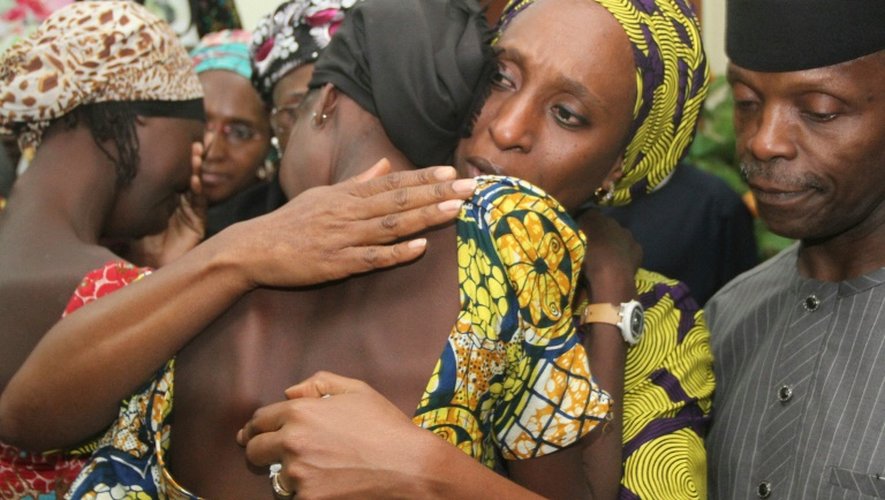 Le vice-président du Nigeria Yemi Osinbajo (d) regarde sa femme Dolapo (c) consoler l'une des 21 jeunes filles de Chibok libérées à Abuja le 13 octobre 2016