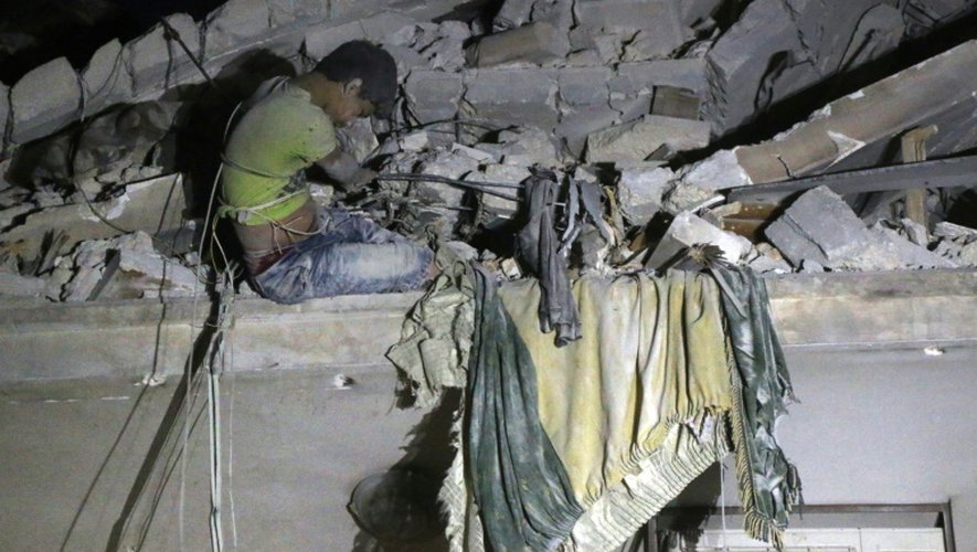 Un adolescent syrien attend d'être secouru dans les ruines d'un immeuble après un raid aérien à Alep, le 16 octobre 2016