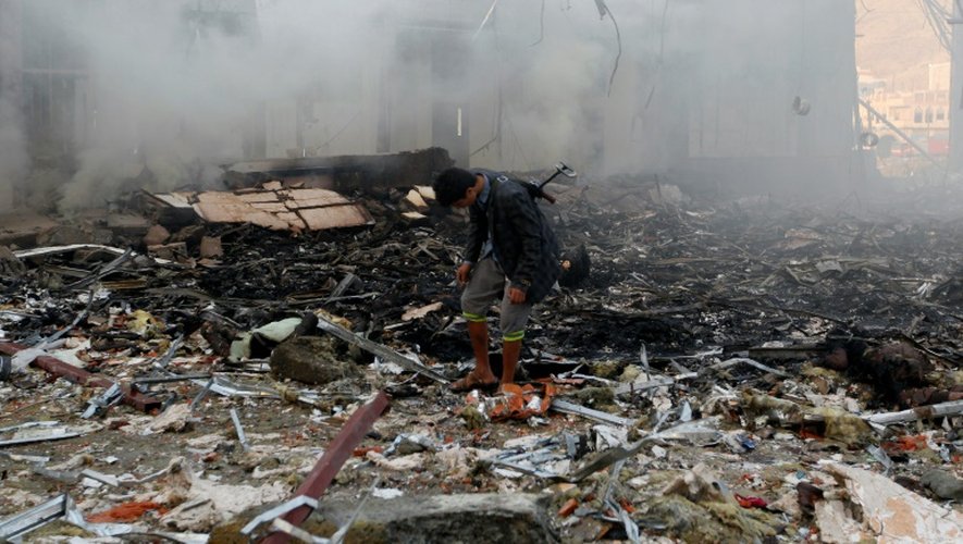 Un Yéménite dans les décombres d'un immeuble, détruit par des bombardements lors de funérailles à Sanaa, le 8 octobre 2016