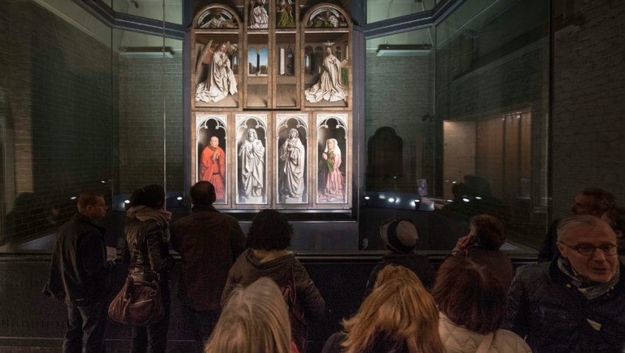 Des visiteurs devant "L'Adoration de l'Agneau mystique", chef-d'oeuvre de la peinture primitive flamand, lors de sa présentation  après sa restauration le 12 octobre 2016  à la cathédrale Saint Bavo à Gand