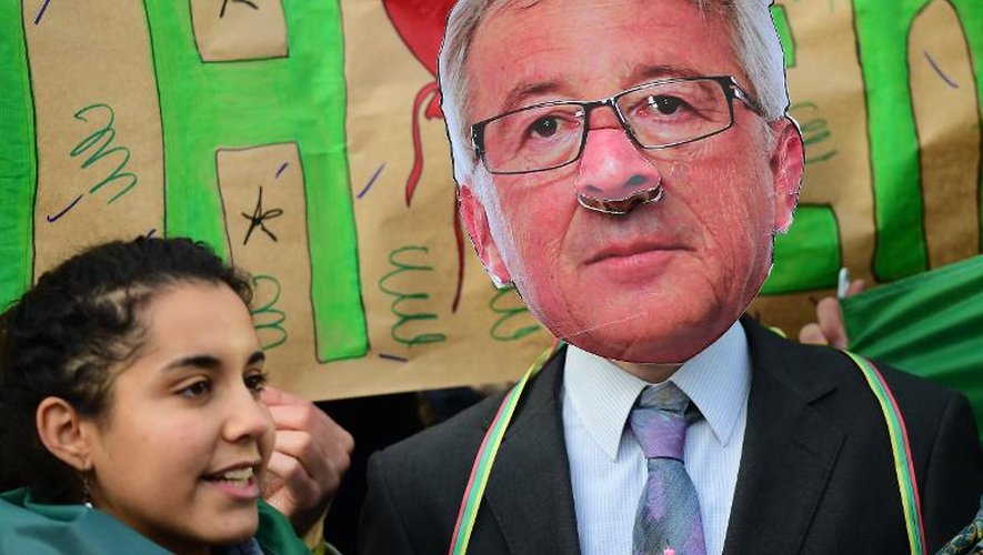 Un militant opposé au Partenariat transatlantique de commerce et d'investissement (TTIP) manifeste devant la Commission européenne à Bruxelle le 9 décembre 2014, un masque du président de la Commission européenne Jean-Claude Juncker sur le visage