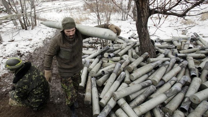 Un militaire ukrainien transport une munition d'artillerie non loin du village de Pisky, près de Donetsk, le 8 décembre 2014