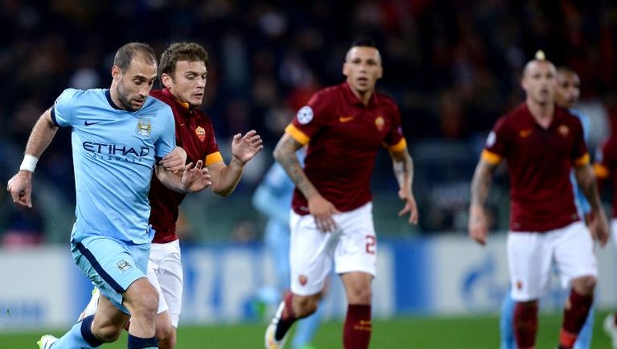 Le défenseur de Manchester City Pablo Zabaleta (g) prend le meilleur sur la défense de la Roma pour marquer le 2e but des Anglais, le 10 décembre 2014 à Rome