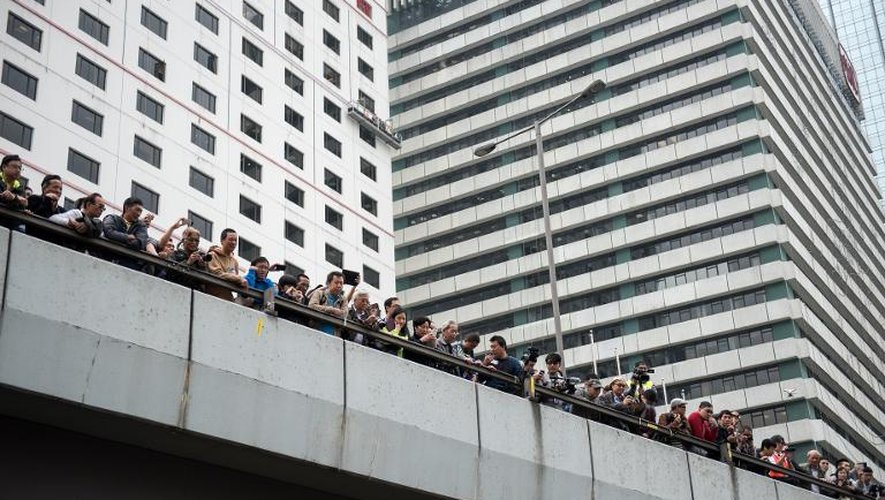 De nombreuses personnes regardent les ouvriers démanteler les barricades construites par les prodémocrates, à Hong Kong, le 11 décembre 2014