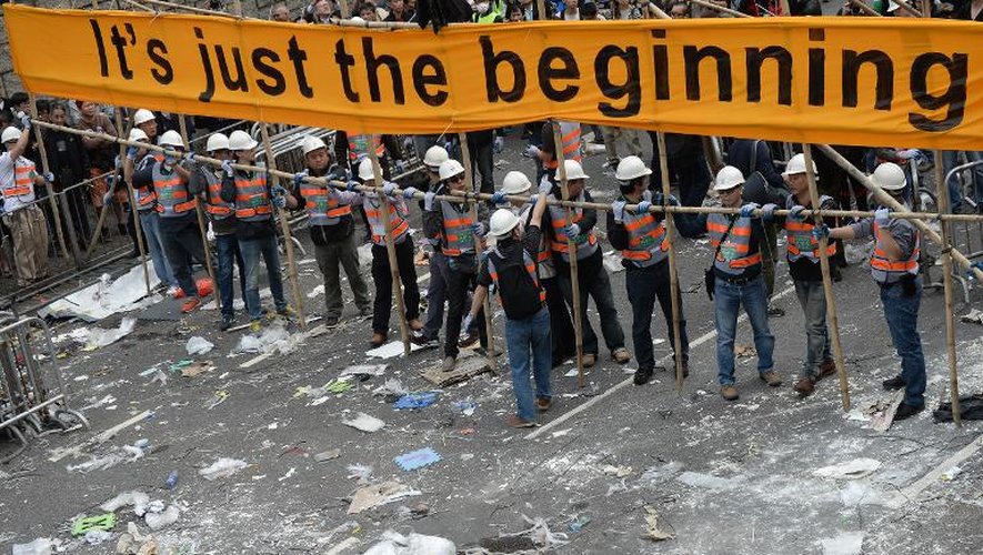 Des ouvriers démantèlent les barricades construites par les prodémocrates, à Hong Kong, le 11 décembre 2014