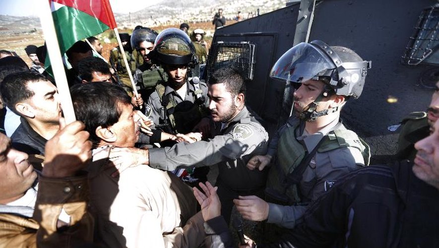 Un policier israélien attrape par le coup Ziad Abu Ein lors d'une manifestation dans les environs de Ramallah le 10 décembre 2014
