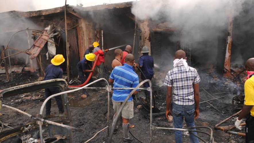 Des pompiers éteignent l'incendie après un attentat à la bombe à Jos le 20 mai 2014
