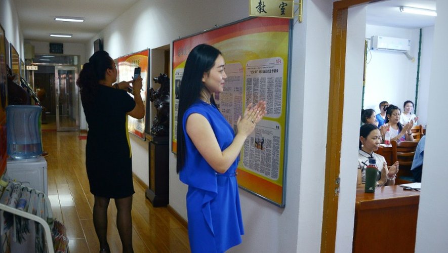 Une femme applaudit lors d'un cours dispensé par Xiu Weiliang sur l'art de la communication, à Harbin le 5 juillet 2015