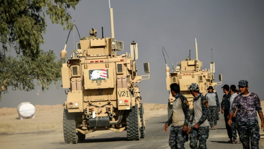 Des soldats irakiens passent devant des blindés utilisés par les forces américaines le 18 octobre 2016 à Qayyarah