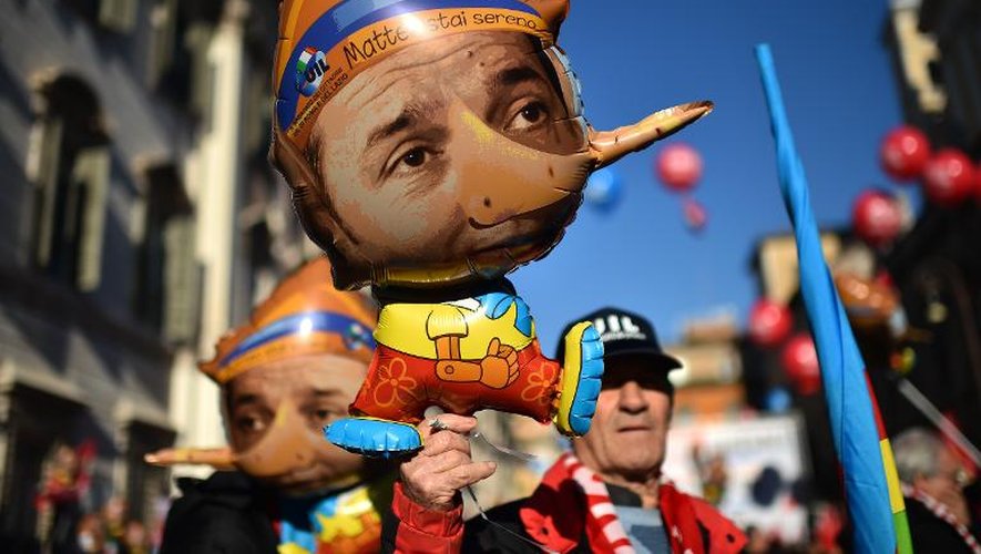 Des manifestants défilent des ballons de baudruche à l'effigie du Premier ministre italien Matteo Renzi grimé en Pinocchio à la main, le 12 décembre 2014 à Rome