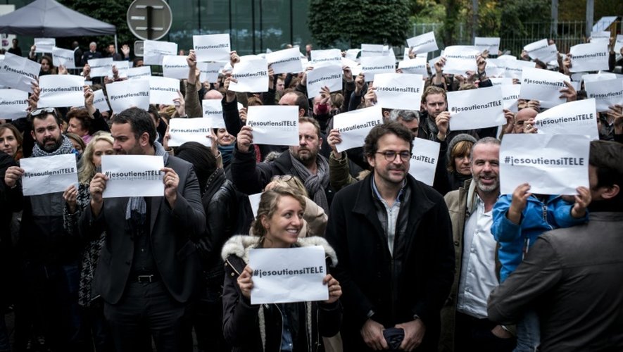 L'équipe de iTELE brandit des pancartes "je soutiens iTELE" devant le siège de la chaîne à Boulogne-Billancourt le 19 octobre 2016