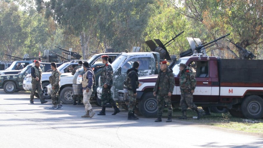 Des membres des forces gouvernementales syriennes montent la garde alors que des rebelles évacuent un quartier de Homs le 9 décembre 2015